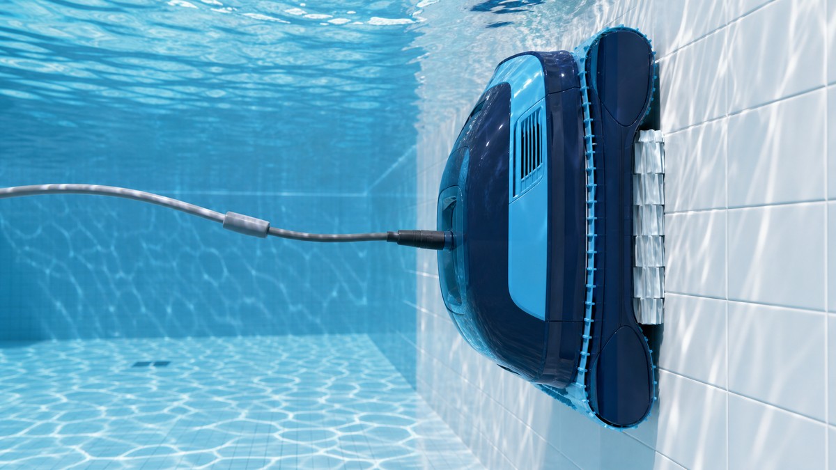 Robô limpa-fundos elétrico Dolphin a trepar pela parede interior de uma piscina com liner azul