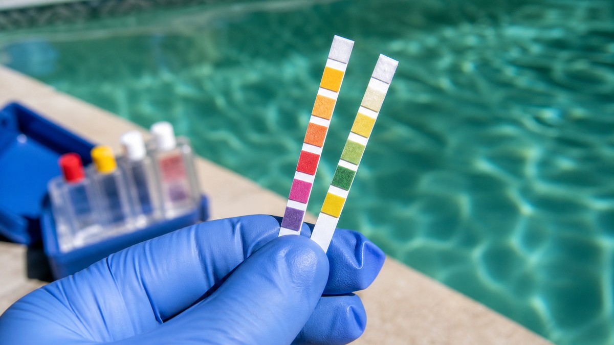 Tiras de análise de água de piscina a mostrar pH e cloro durante um tratamento de choque